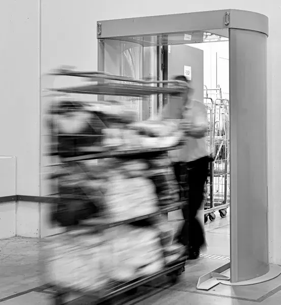 Person pushing cart through security scanner