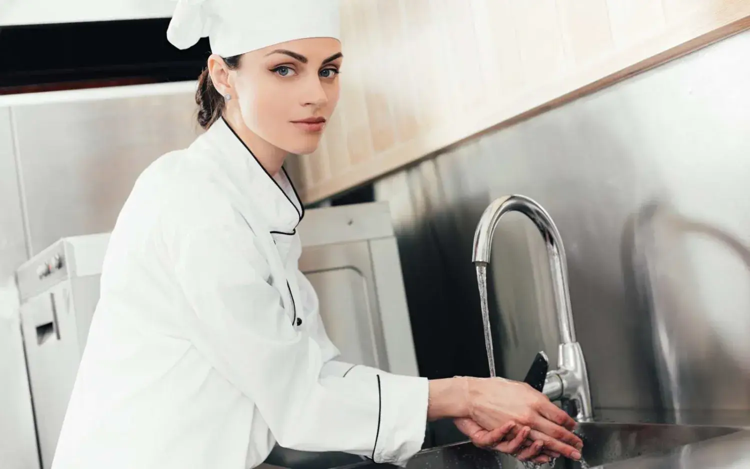 Hygiëne in de horeca met een vrouwelijke kok die haar handen wast