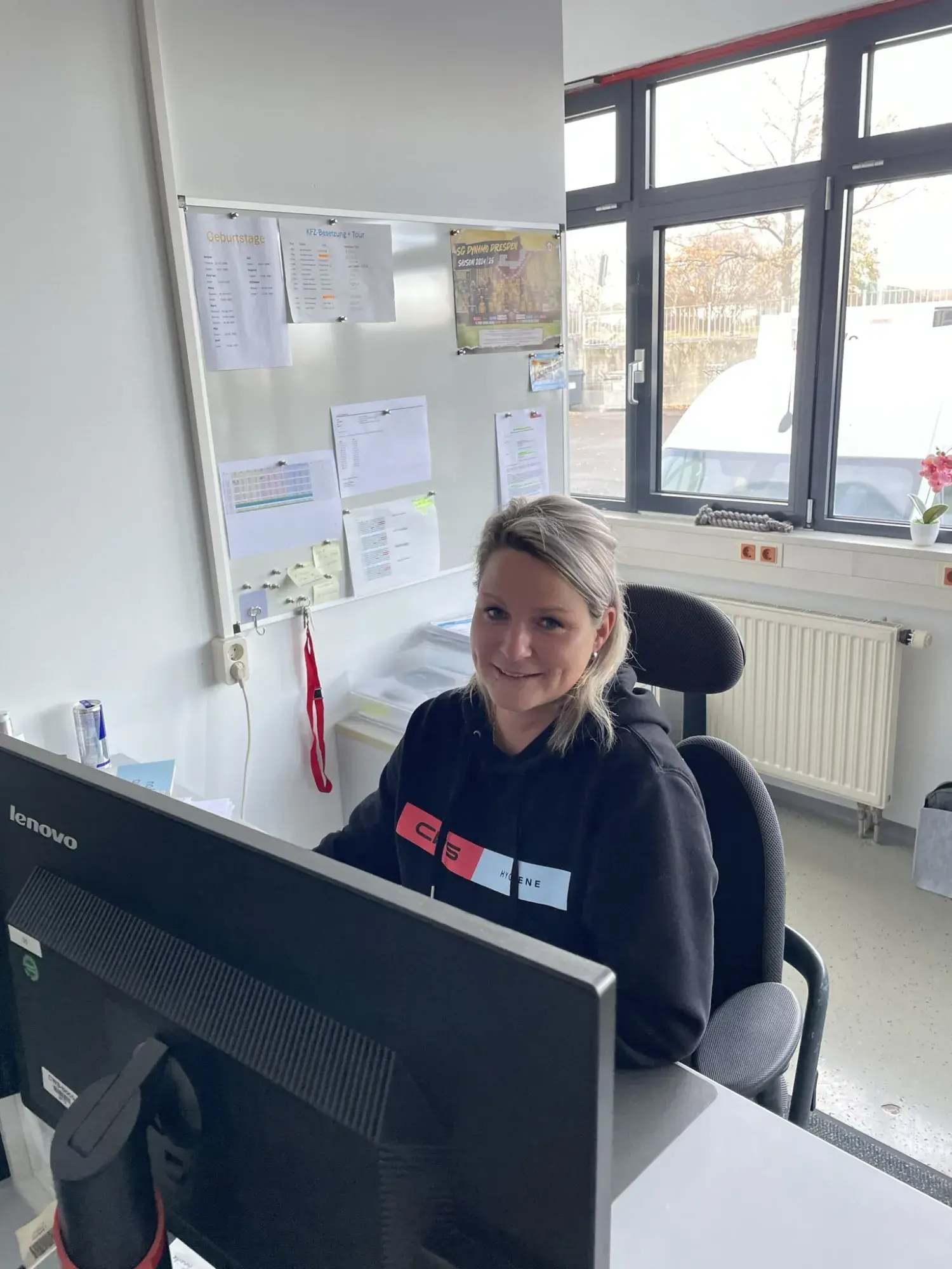 Justine Hoffmann sitting on her desk in the office.