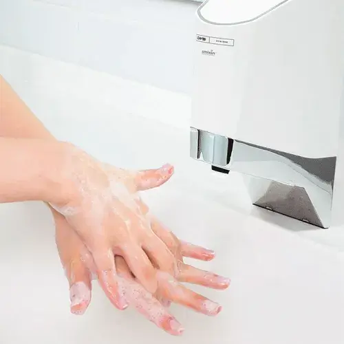 Zwei Hände werden unter der CWS SmartWash Wascharmatur eingeseift.