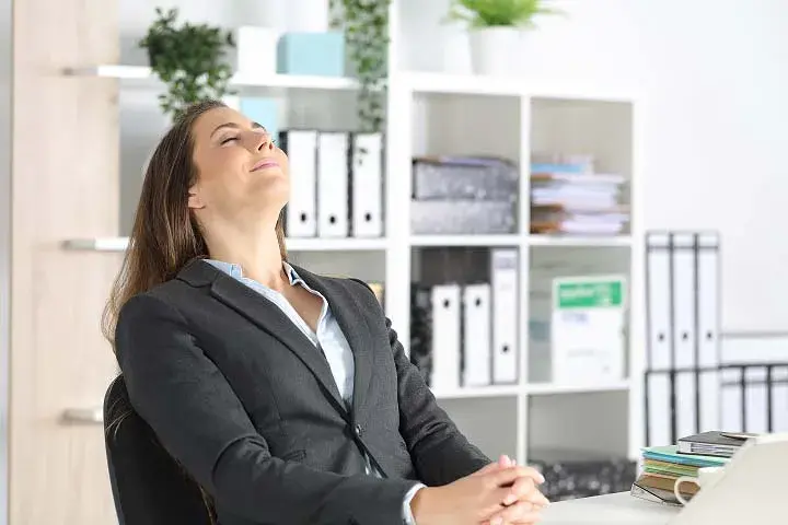 Woman breathing in fresh air in the office