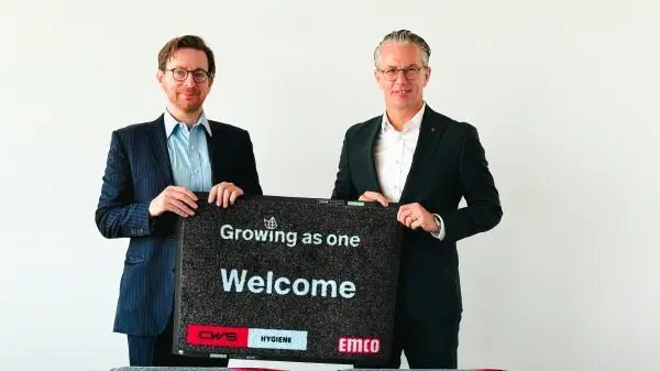 CEOs of both companies displaying mats 